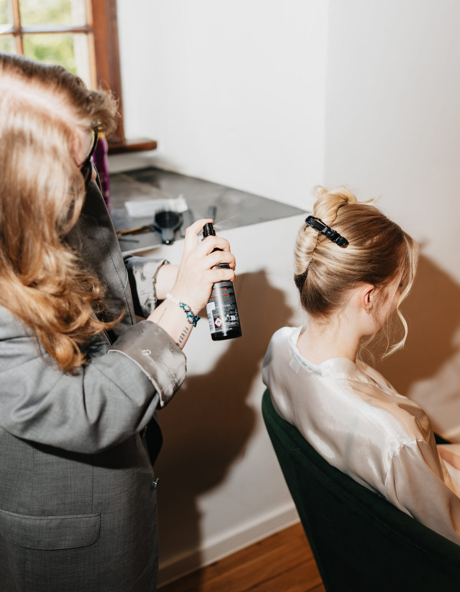 Haarspray wird zur Fixierung auf die Brautfrisur aufgetragen
